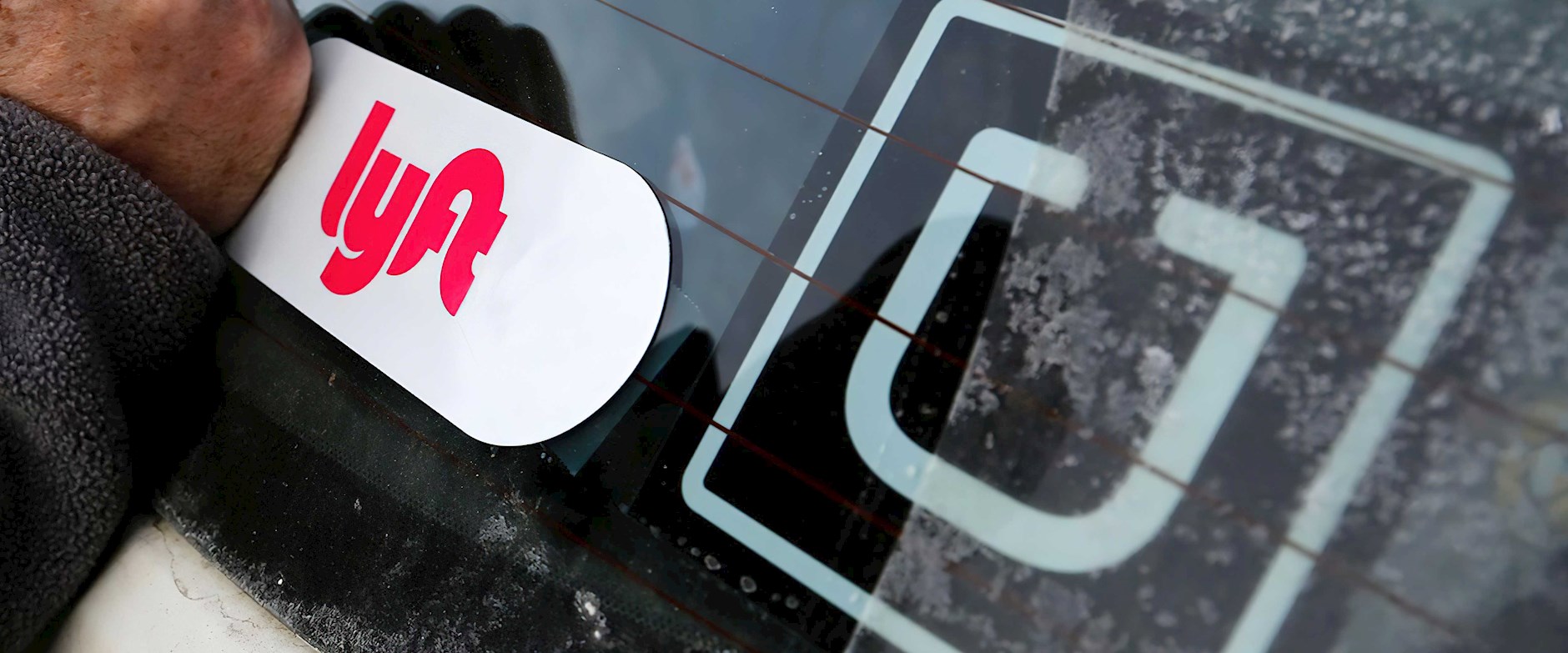 Car window with Uber and Lyft stickers