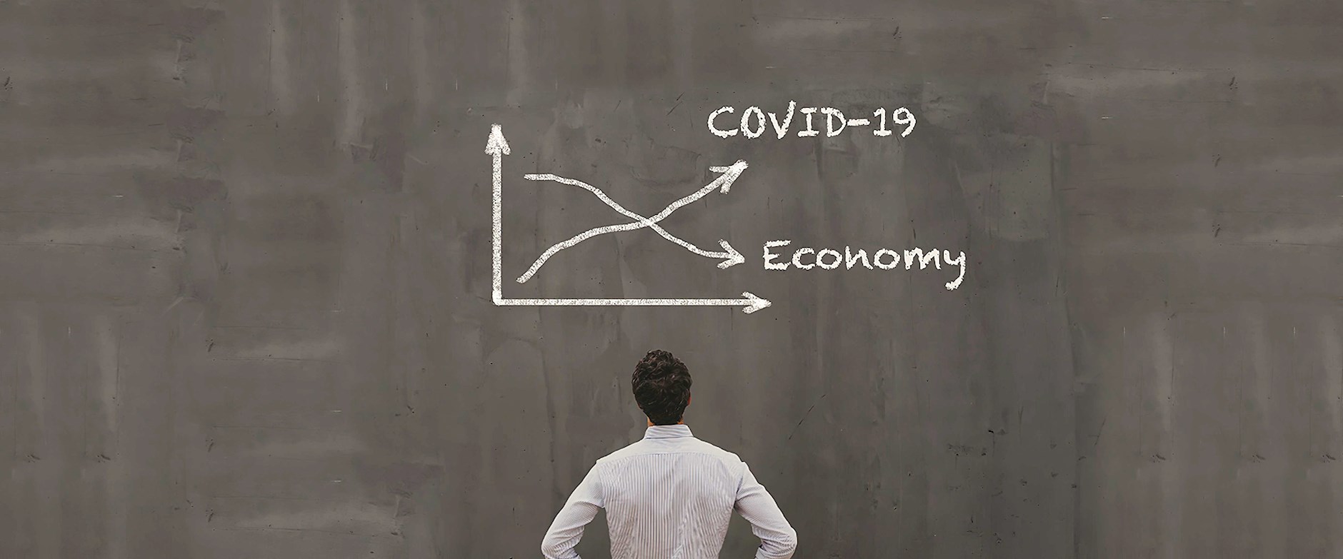 Man looking at covid-19 chart on chalkboard